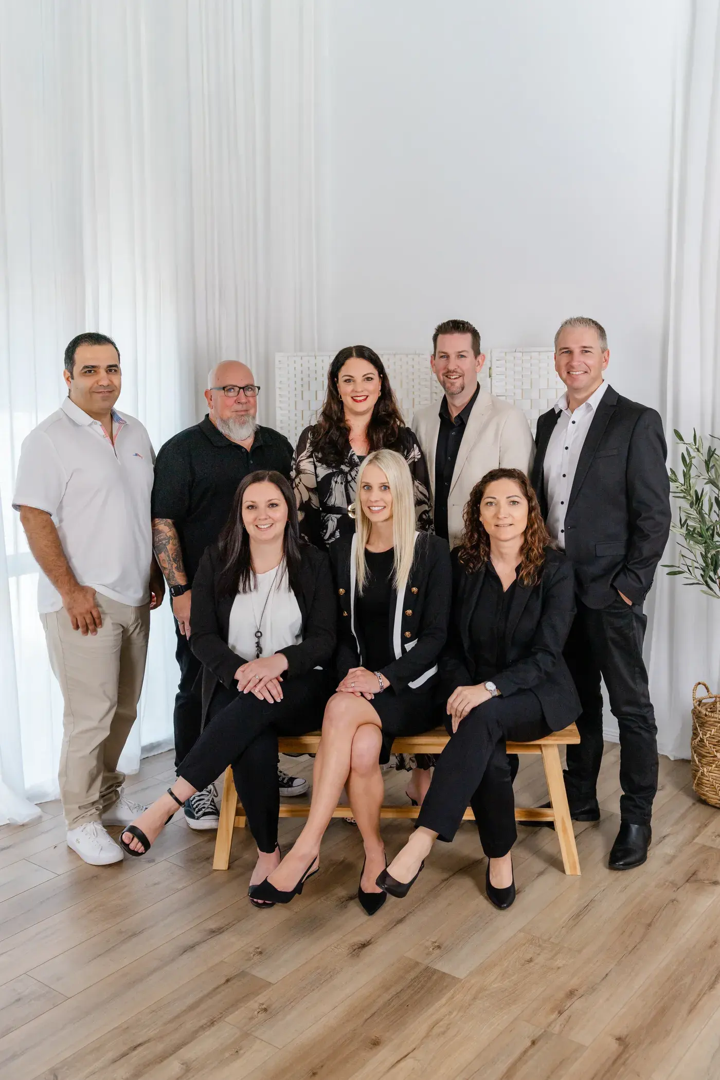The Touch Residential team, five standing behind three seated on a timber bench